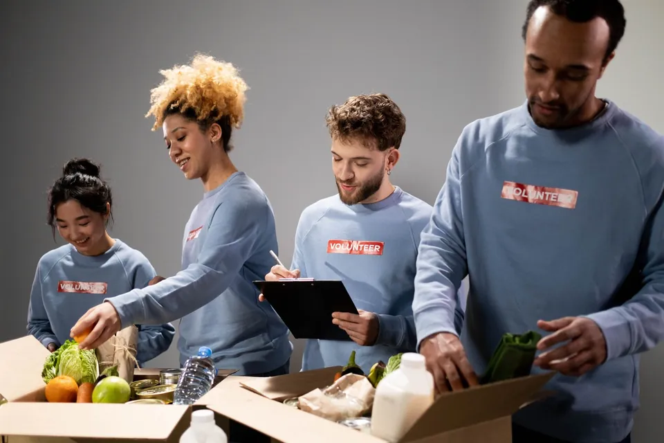 Voluntarios arman cajas de despensa con frutas y verduras